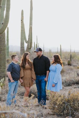 Casual group portrait session in Arizona desert surrounded by giant saguaro cacti.