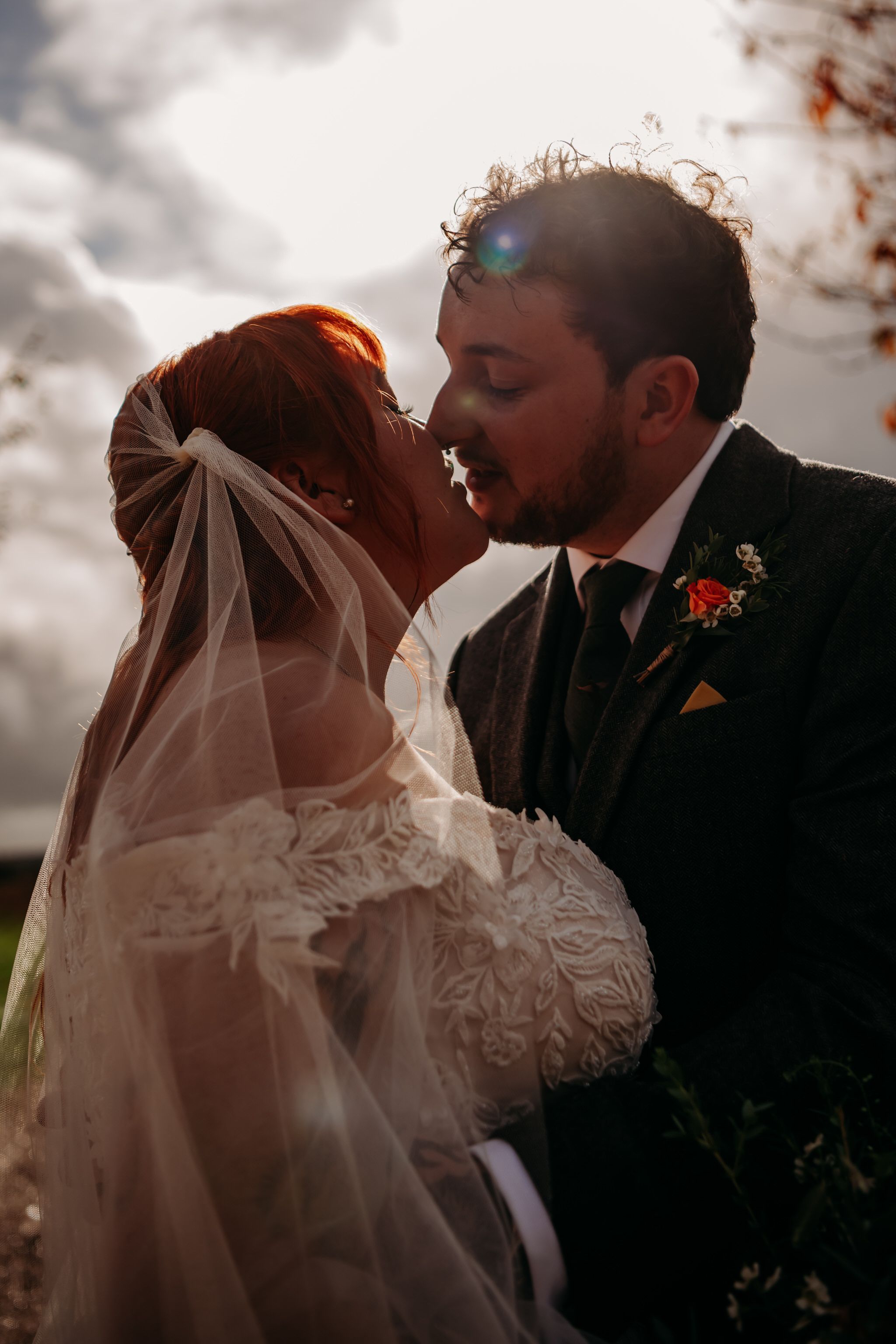 A romantic wedding kiss sequence showing a couple in traditional attire with a flowing veil against a cloudy sky.
