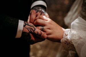 Close-up shot of hands exchanging wedding rings during a romantic ceremony.