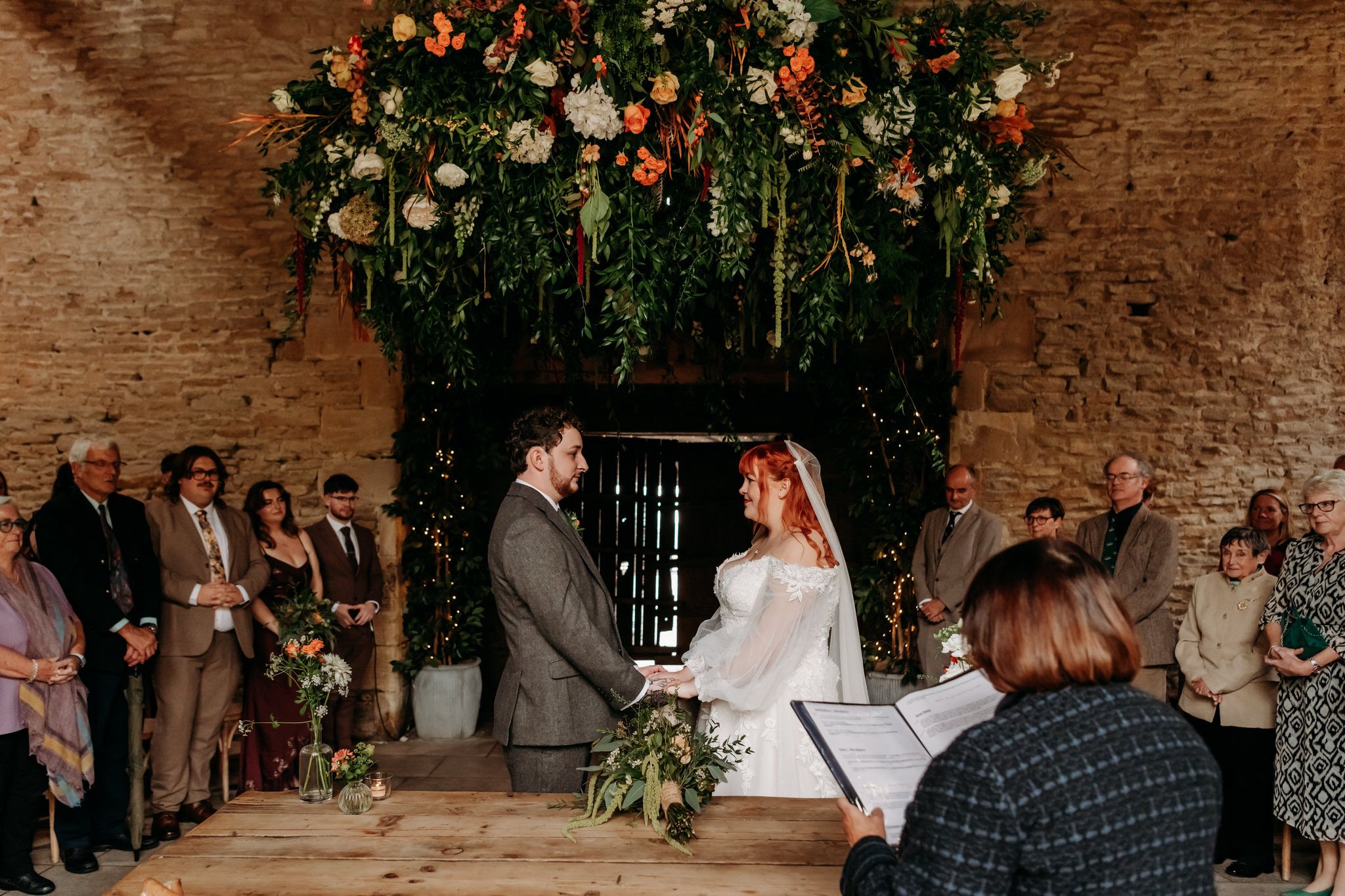 A series of wedding photos showing couples dancing and celebrating in a rustic brick-walled venue with floral decorations.
