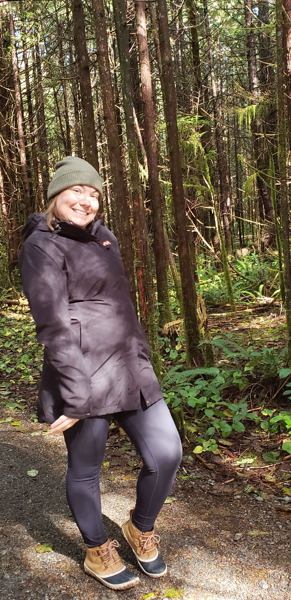 a women stands in the woods.