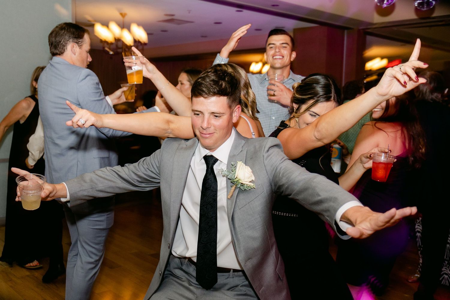 Groom dancing on dance floor with disco balls, captured by Clearwater wedding photographers