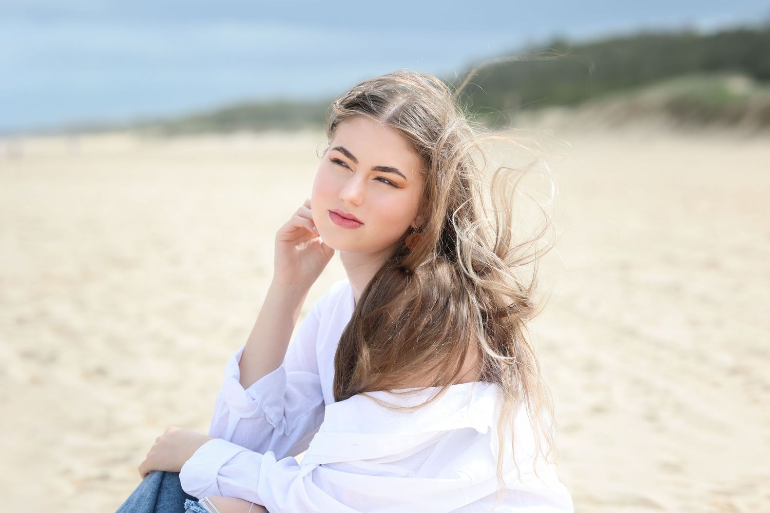 Four connected images show someone in a white top posing on a sandy beach with natural lighting and coastal scenery.