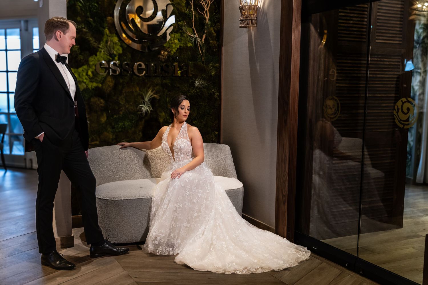 Wedding couple posing against architectural columns and windows in an elegant venue.