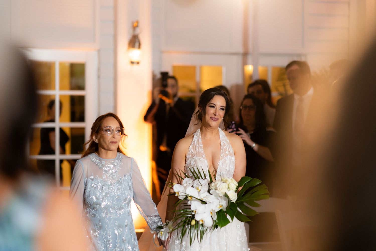 Wedding ceremony at a beautifully decorated indoor venue with warm lighting.