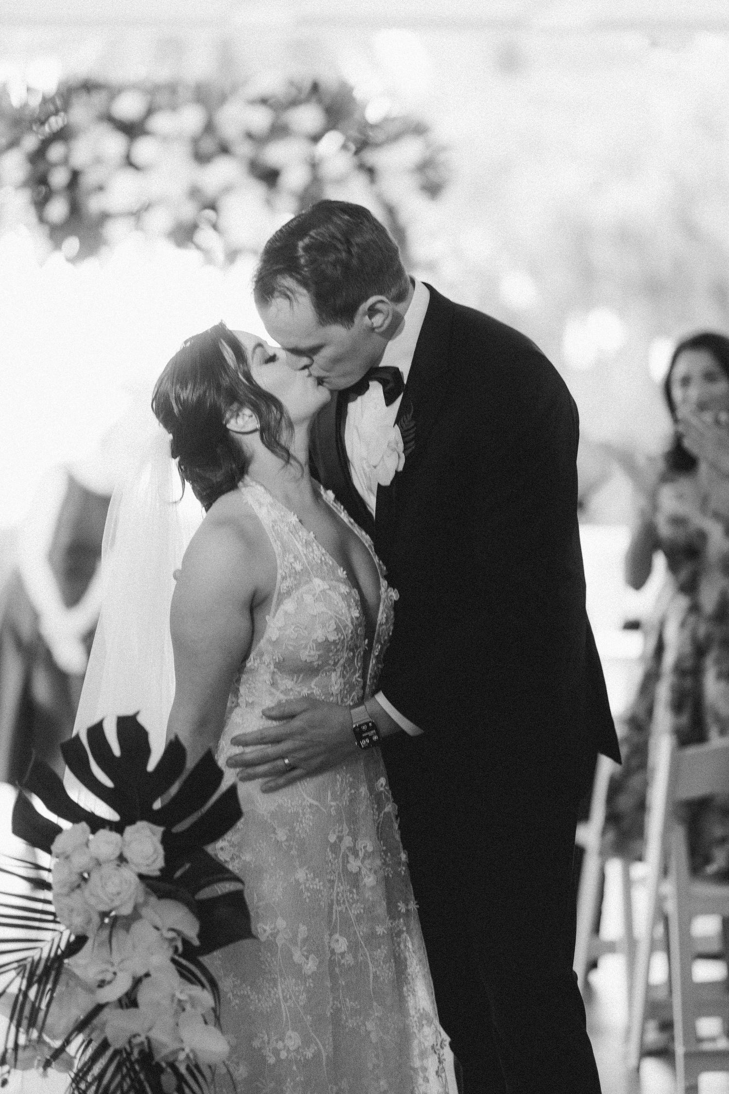 Black and white photo of a romantic wedding kiss during the ceremony.