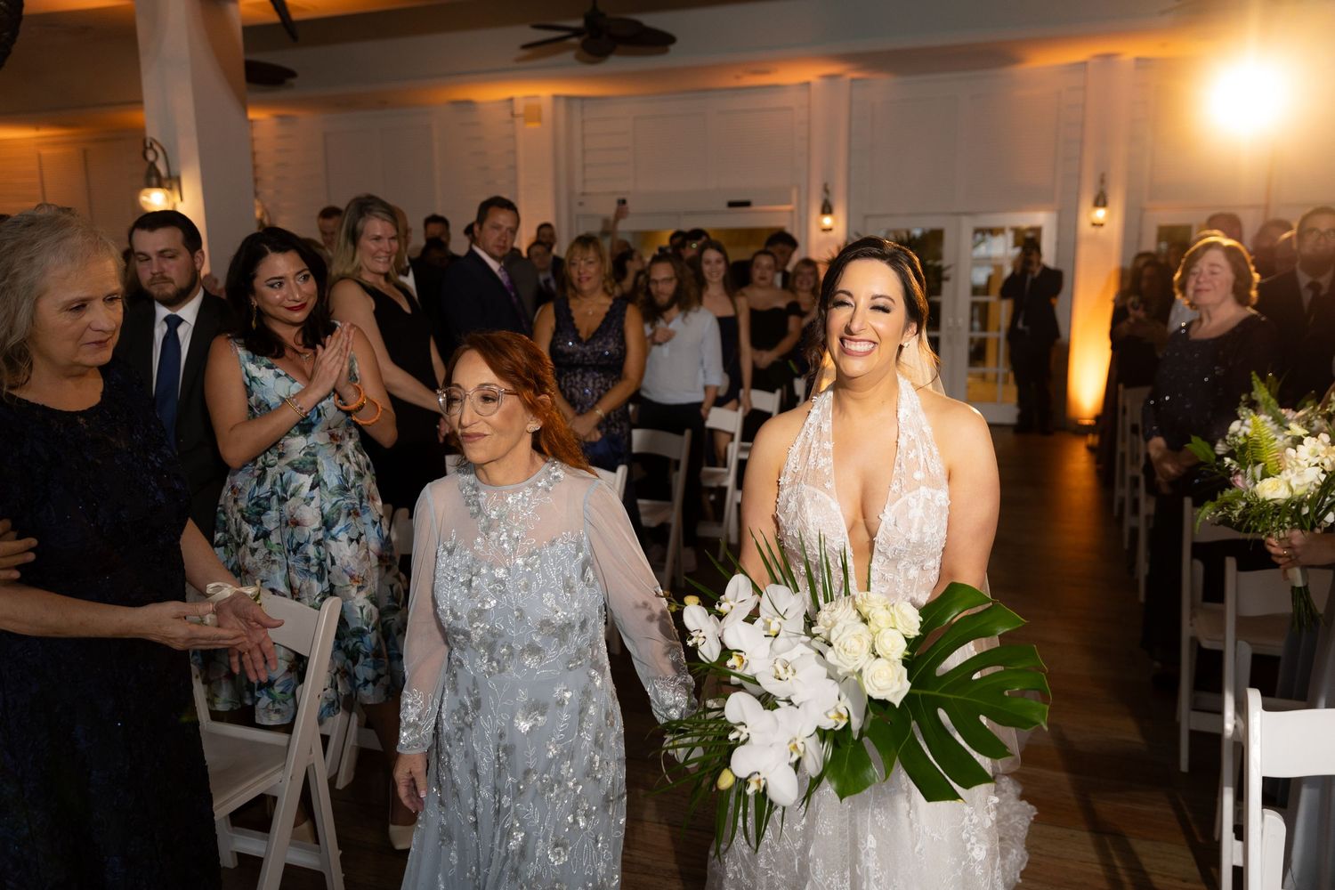 Joyful wedding reception with guests celebrating in an elegantly decorated venue.