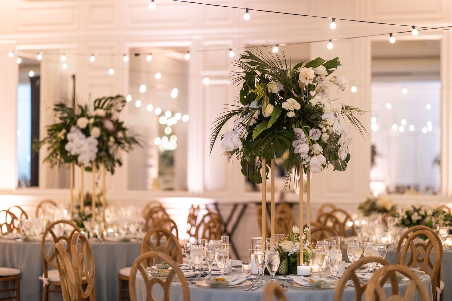 Elegant wedding reception venue decorated with white floral centerpieces and warm lighting creating a romantic ambiance.