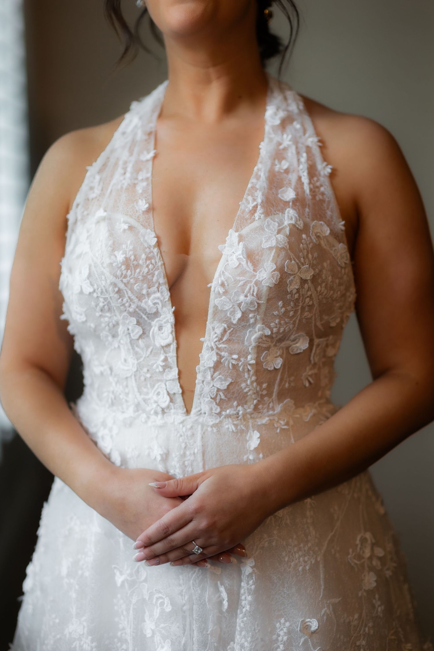 Detailed view of delicate lace wedding dress bodice with plunging neckline.
