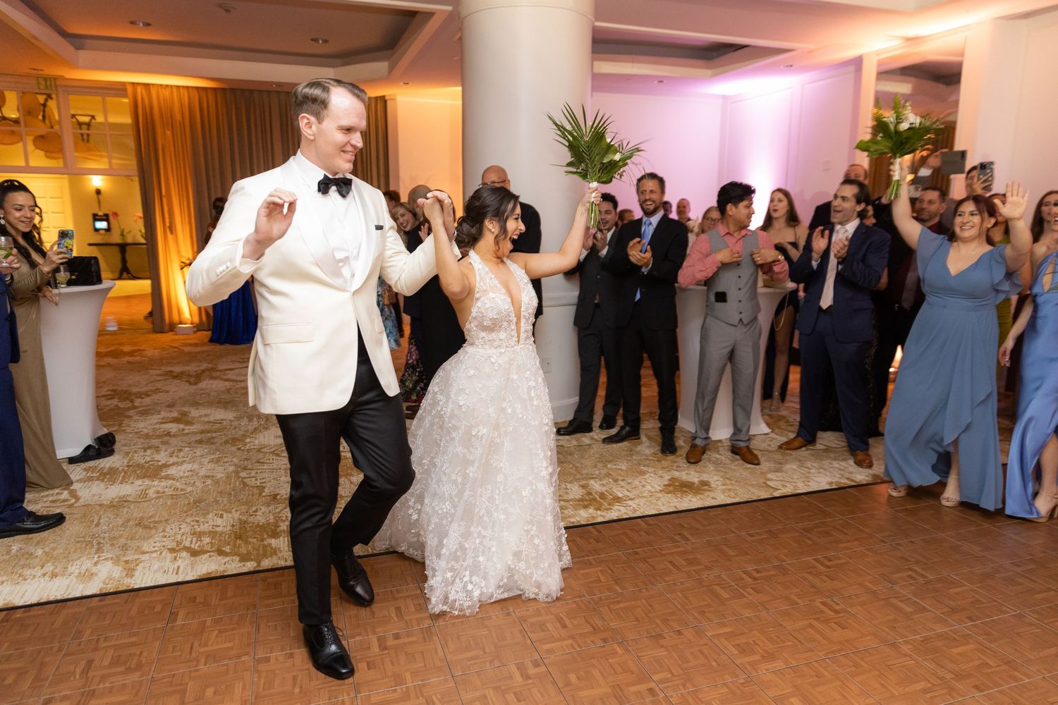 Wedding reception dance floor filled with celebration as couple performs special choreography.