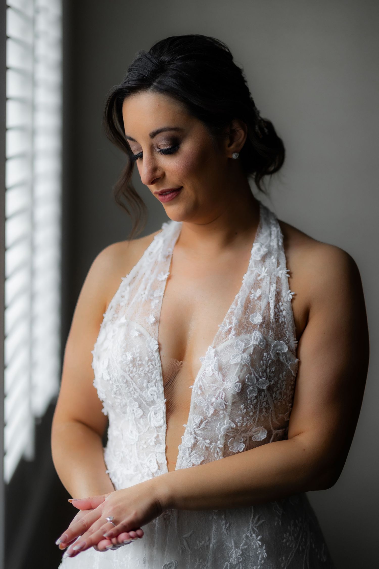 Intimate bridal portrait showcasing elegant makeup and lace dress details.