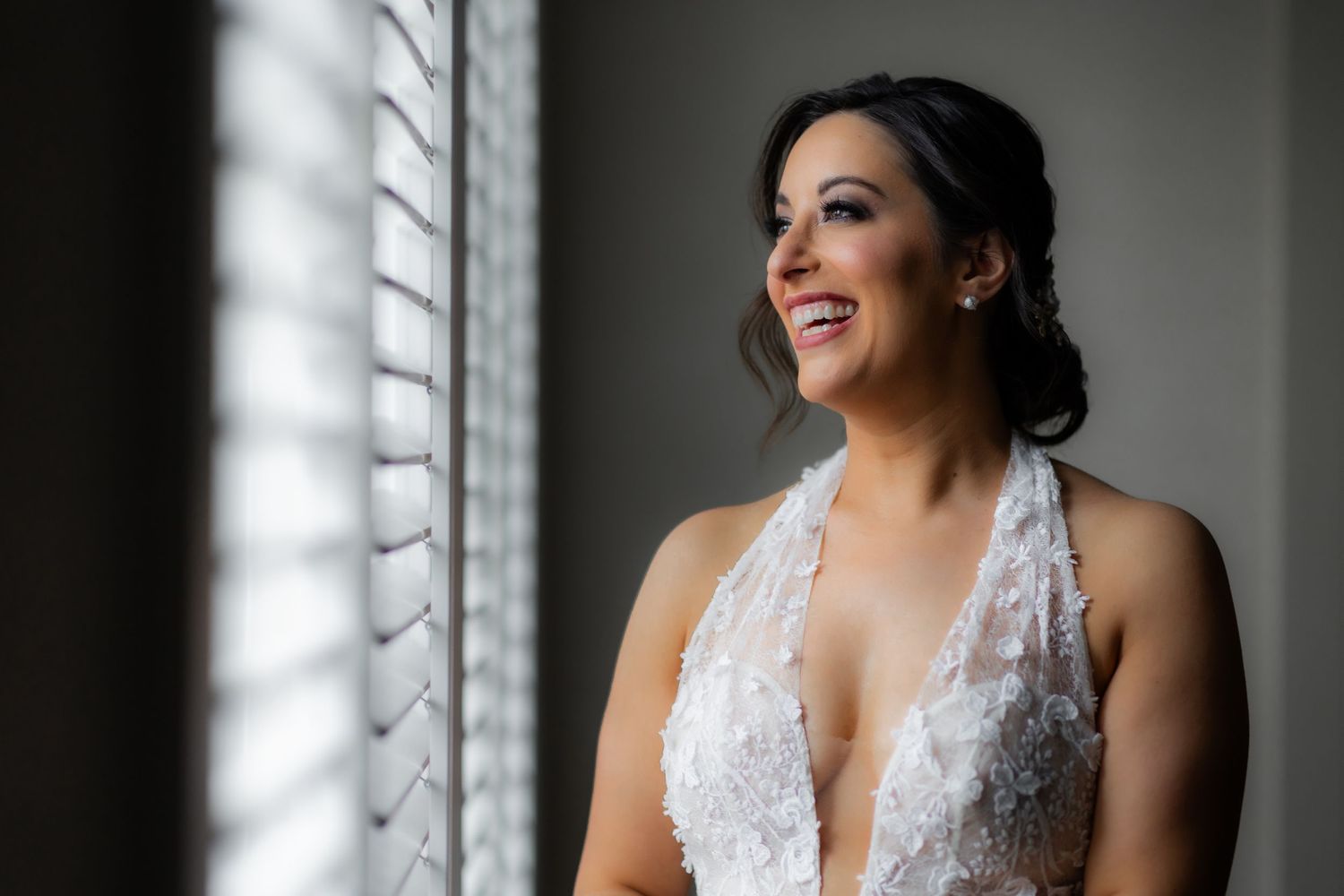 Close-up wedding portrait showing a bride in a white lace gown with an elegant updo hairstyle.