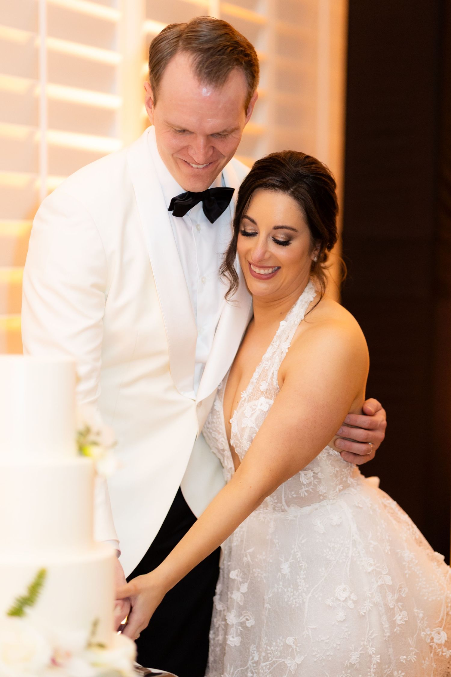 Close-up of romantic dance moment during wedding reception with warm lighting.
