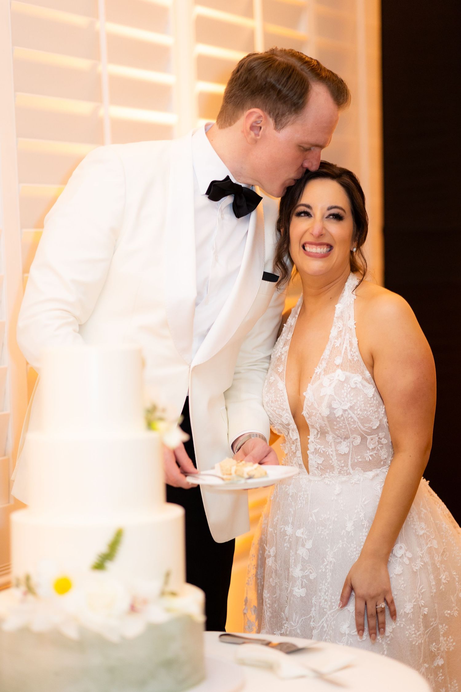 Couple shares an intimate moment of laughter during their wedding cake cutting ceremony.