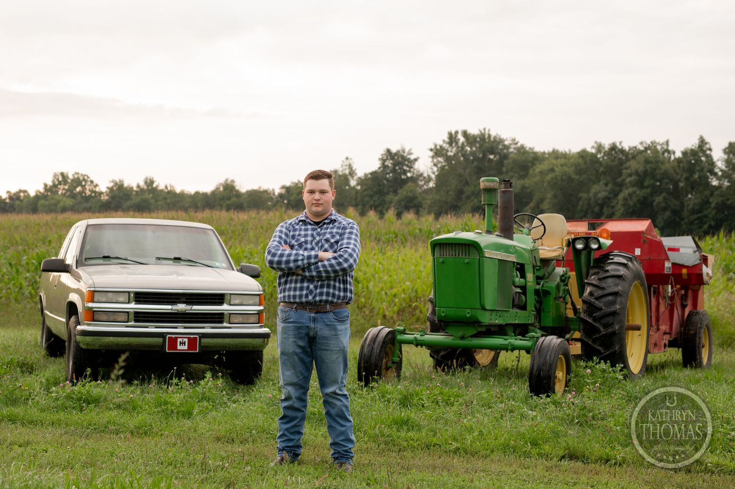 A vintage Chevrolet pickup truck and John Deere tractors frame a rural farm scene.