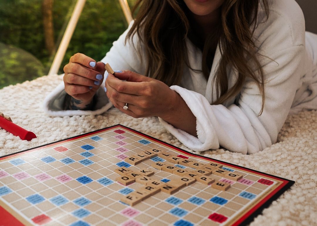 Board game being played on a comfortable bed inside a luxury camping dome.