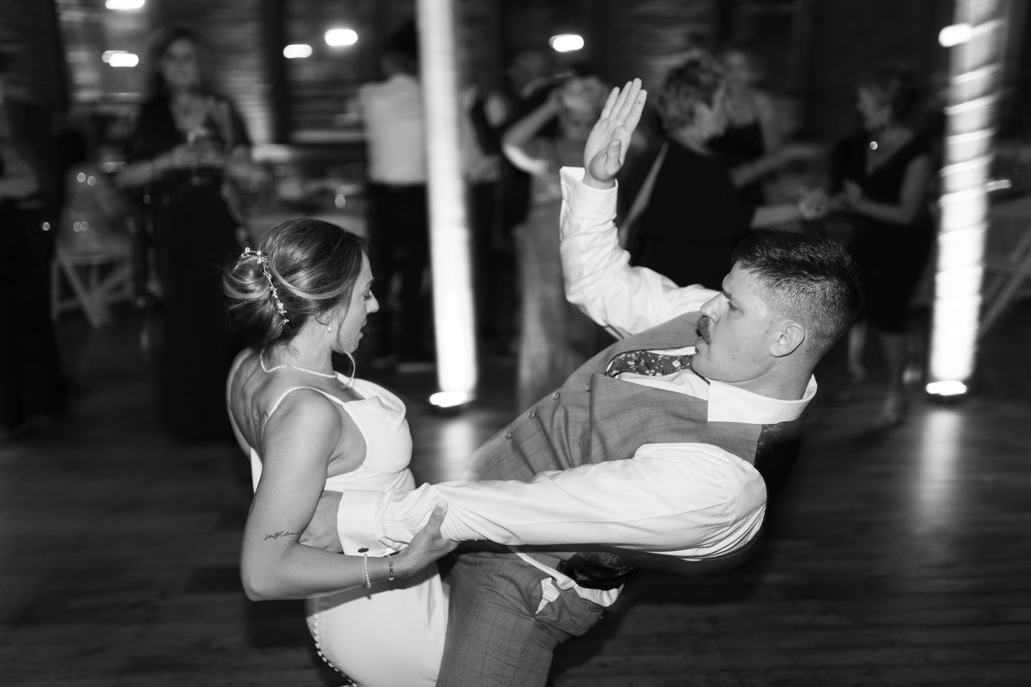 Dynamic black and white photo of couple performing dramatic dance move.
