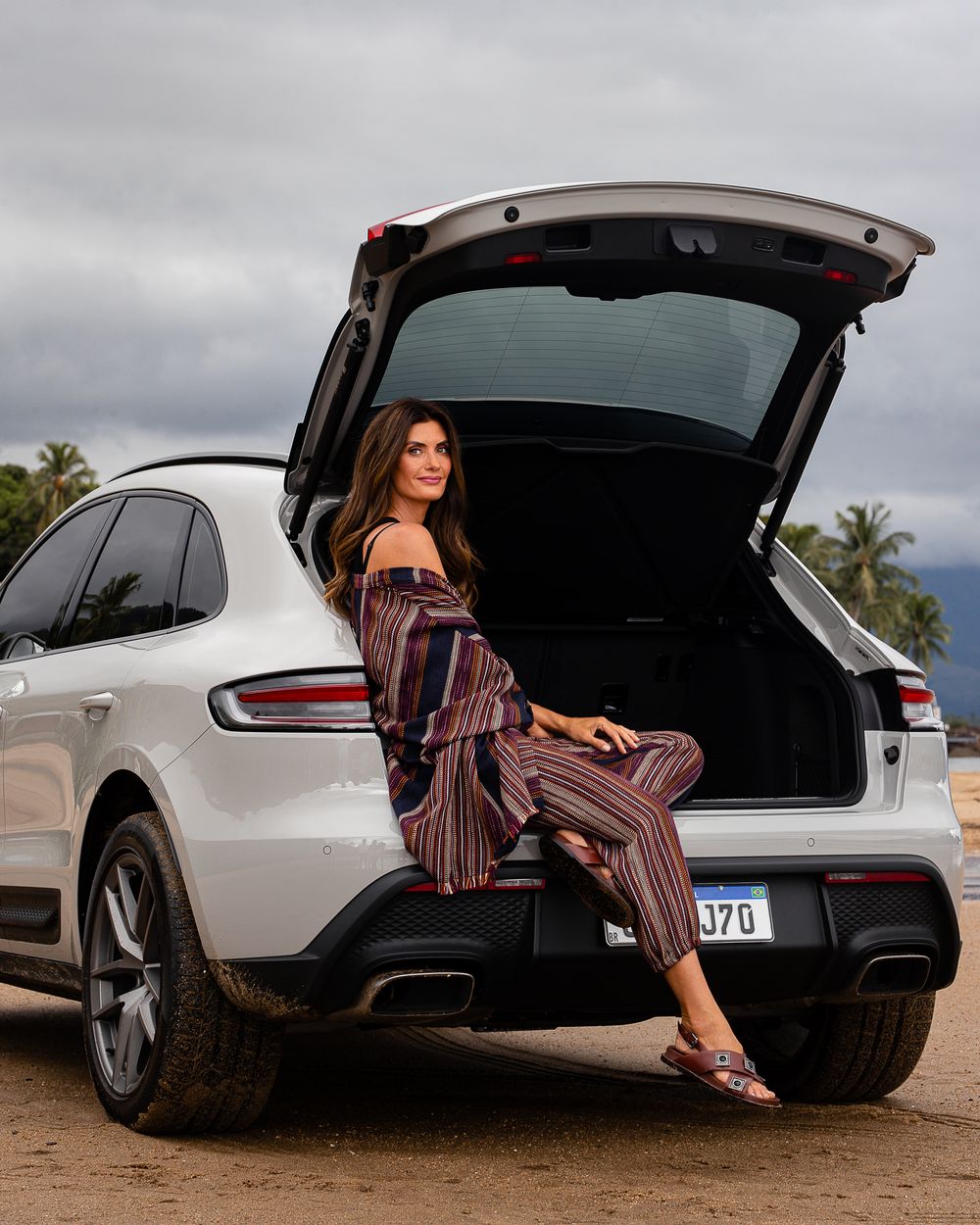 Lifestyle photography with luxury vehicles and casual fashion in an outdoor setting.