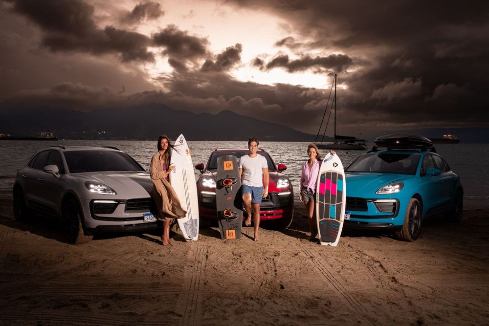 Dramatic sunset photoshoot featuring multiple luxury vehicles lined up on beach location.