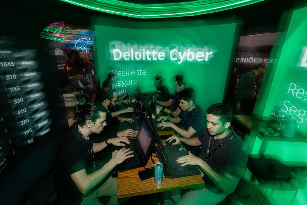 Cyber security event space with green lighting and interactive displays.