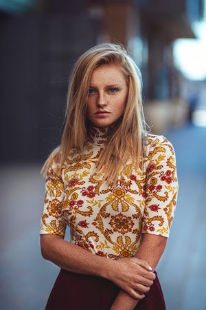 Retro-style portrait featuring yellow and brown floral print top with short puff sleeves.