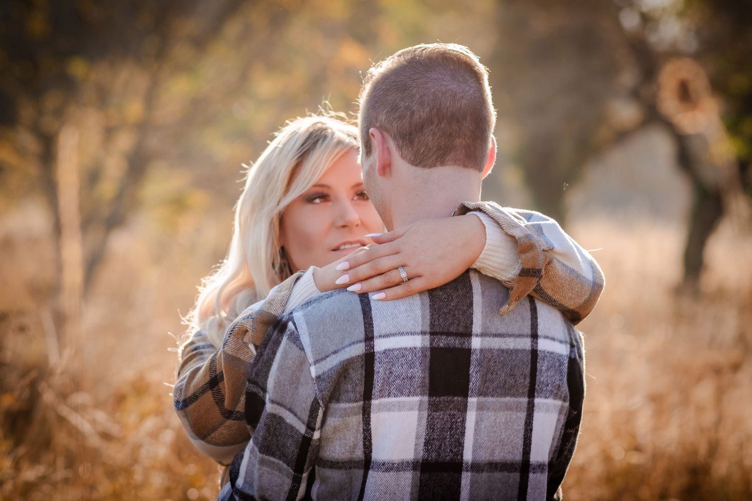 Autumn engagement photo session featuring warm golden sunlight and plaid clothing.