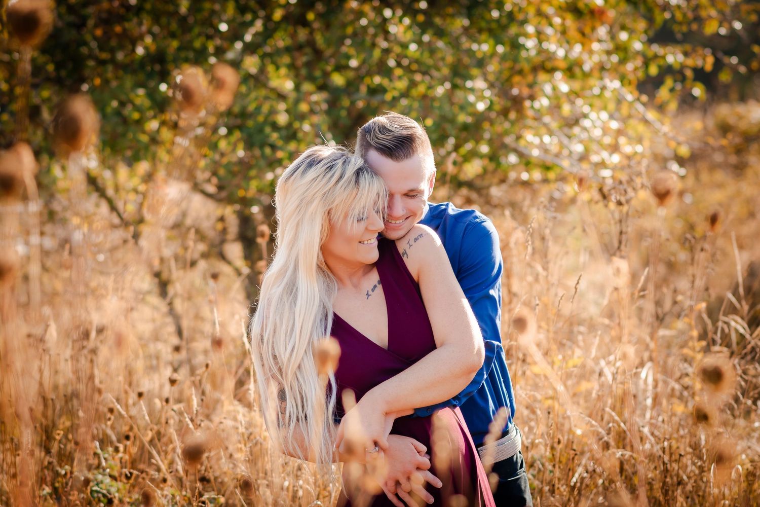 Romantic couple portrait in a golden field during sunset with natural autumn colors.