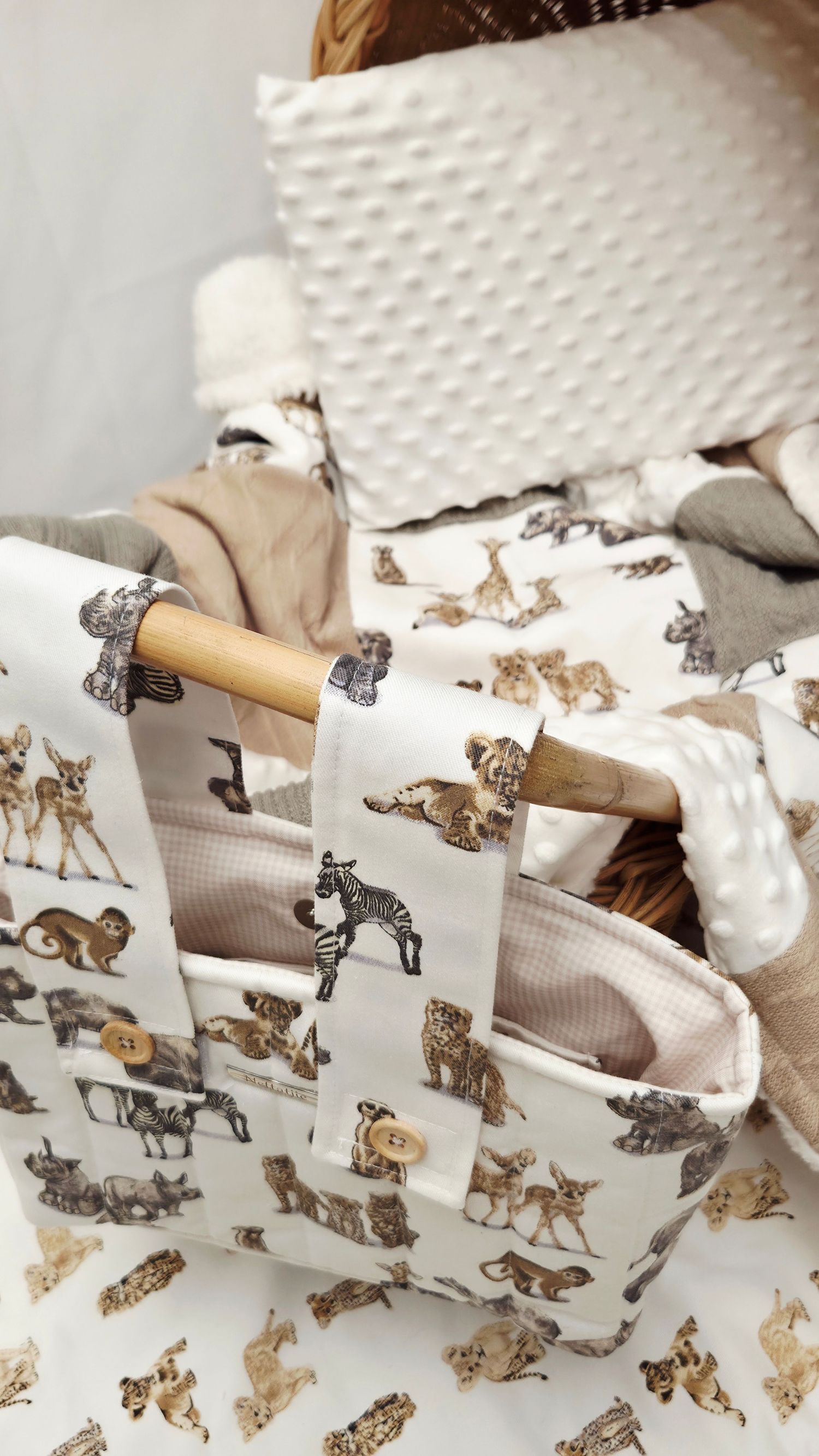 Handmade fabric tote bag with safari animal print pattern and wooden handle, displayed in a wicker basket.