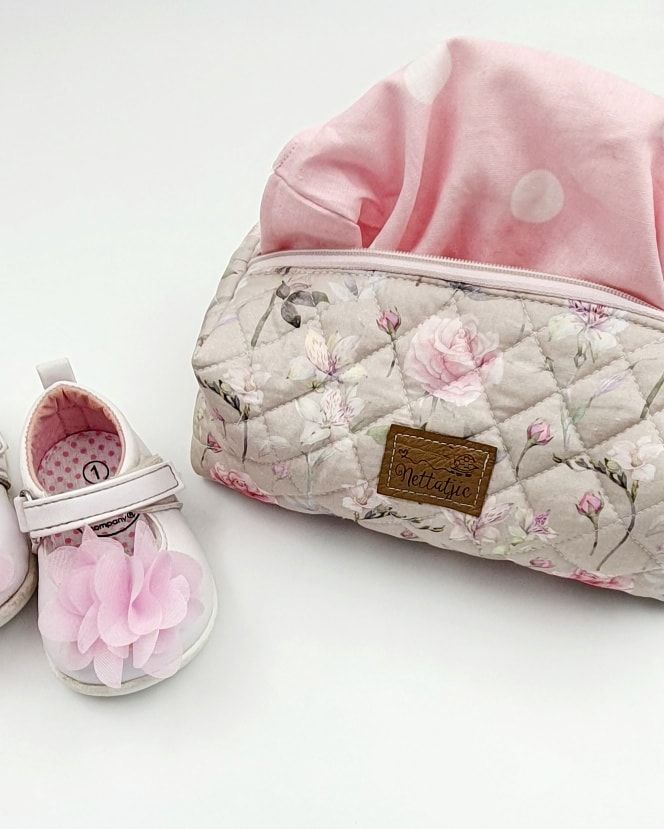 Pink and cream floral nursing pillow cover with leather label detail.