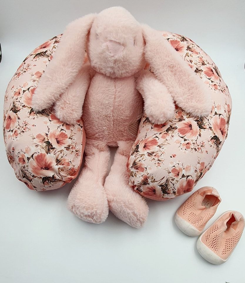 Pink plush nursing pillow with floral pattern shown from different angles.