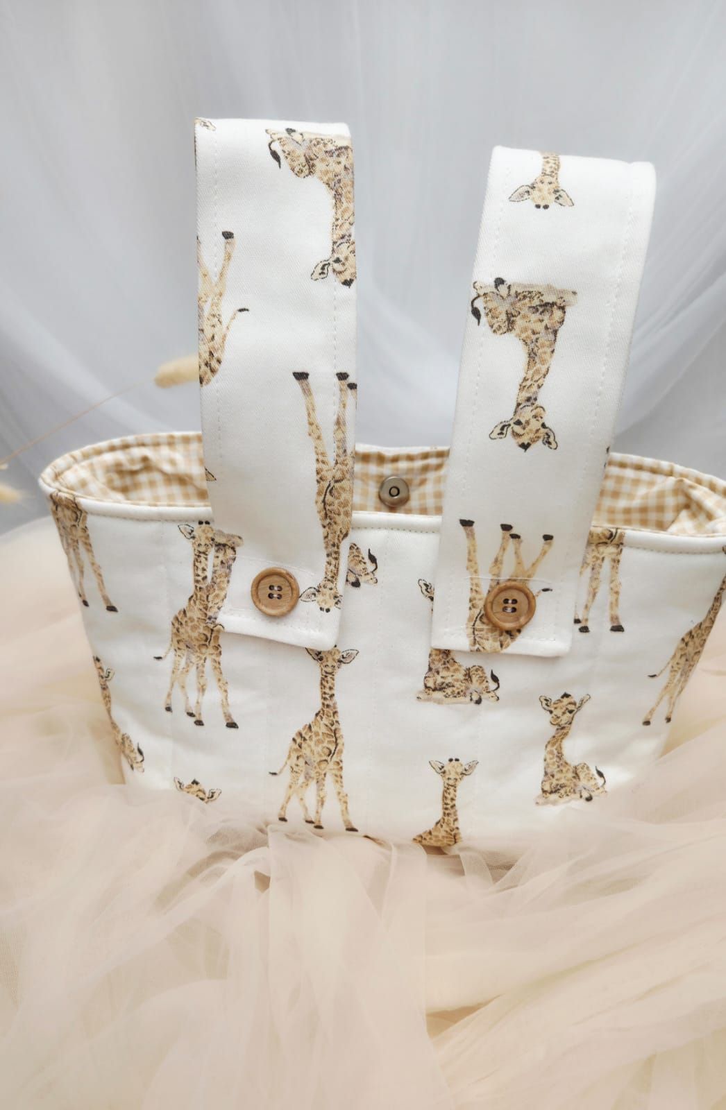 Interior view of white giraffe print tote bag showing tan gingham lining and wooden button closure.
