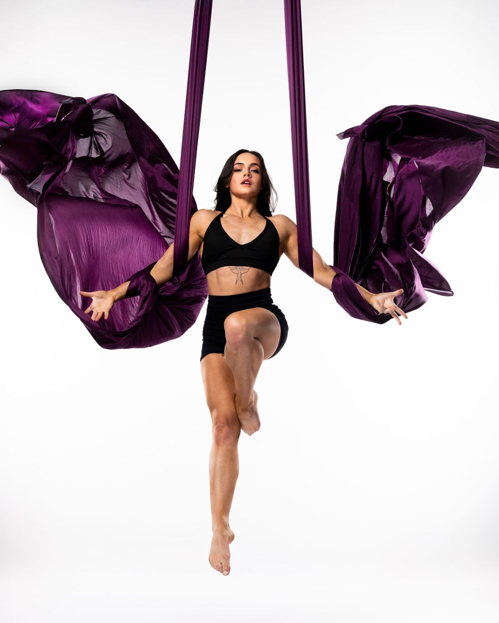 Aerialist in studio on white backdrop; professional aerial arts photography, aerial portraits, and aerialist photoshoot by pro photographer.