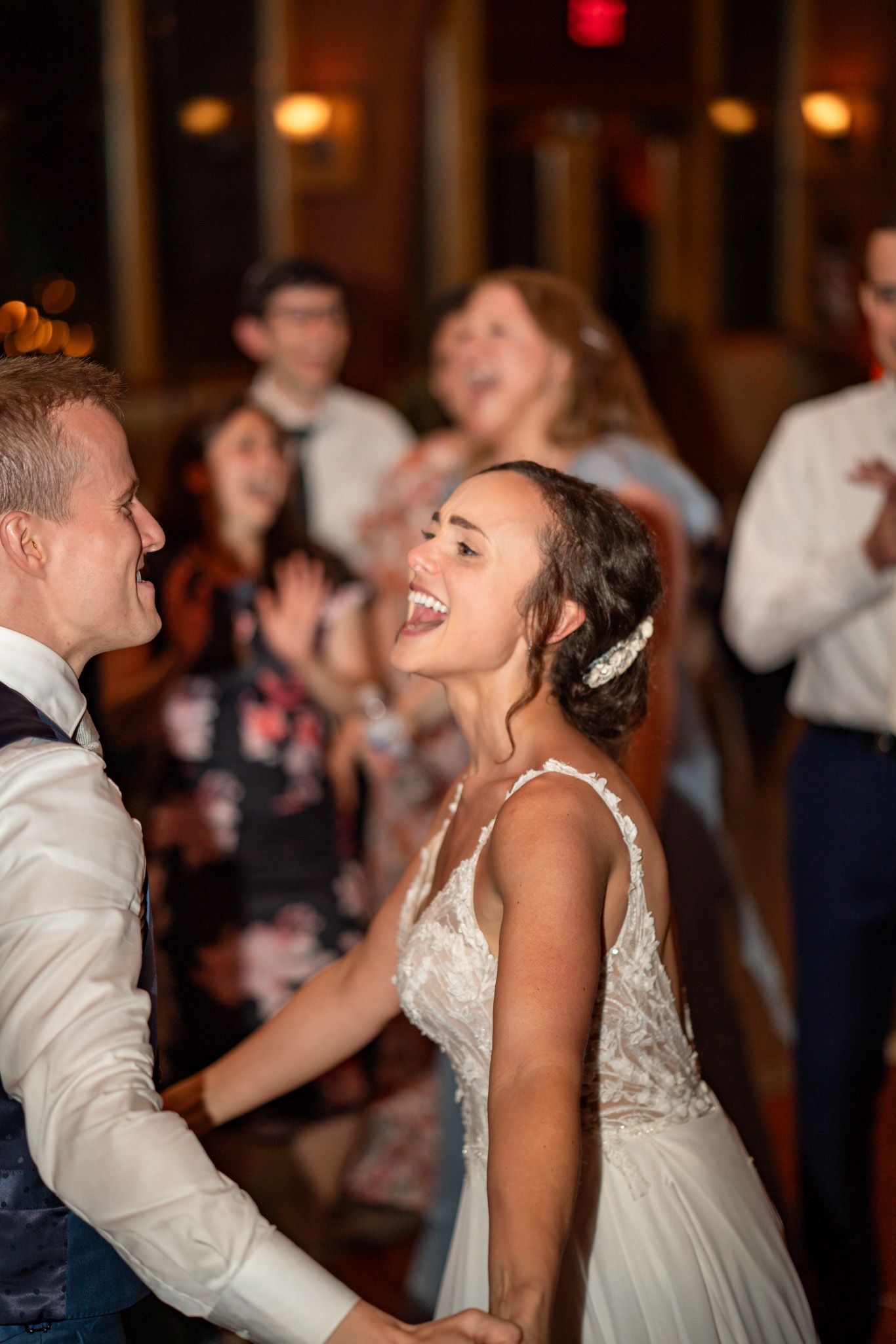 Wedding couple shares joyful laughter while dancing at their reception.