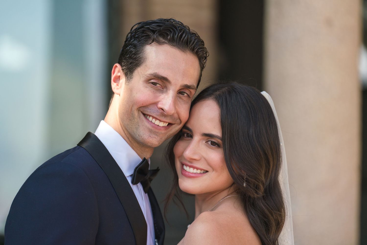 A romantic wedding portrait captured against a classic architectural backdrop.