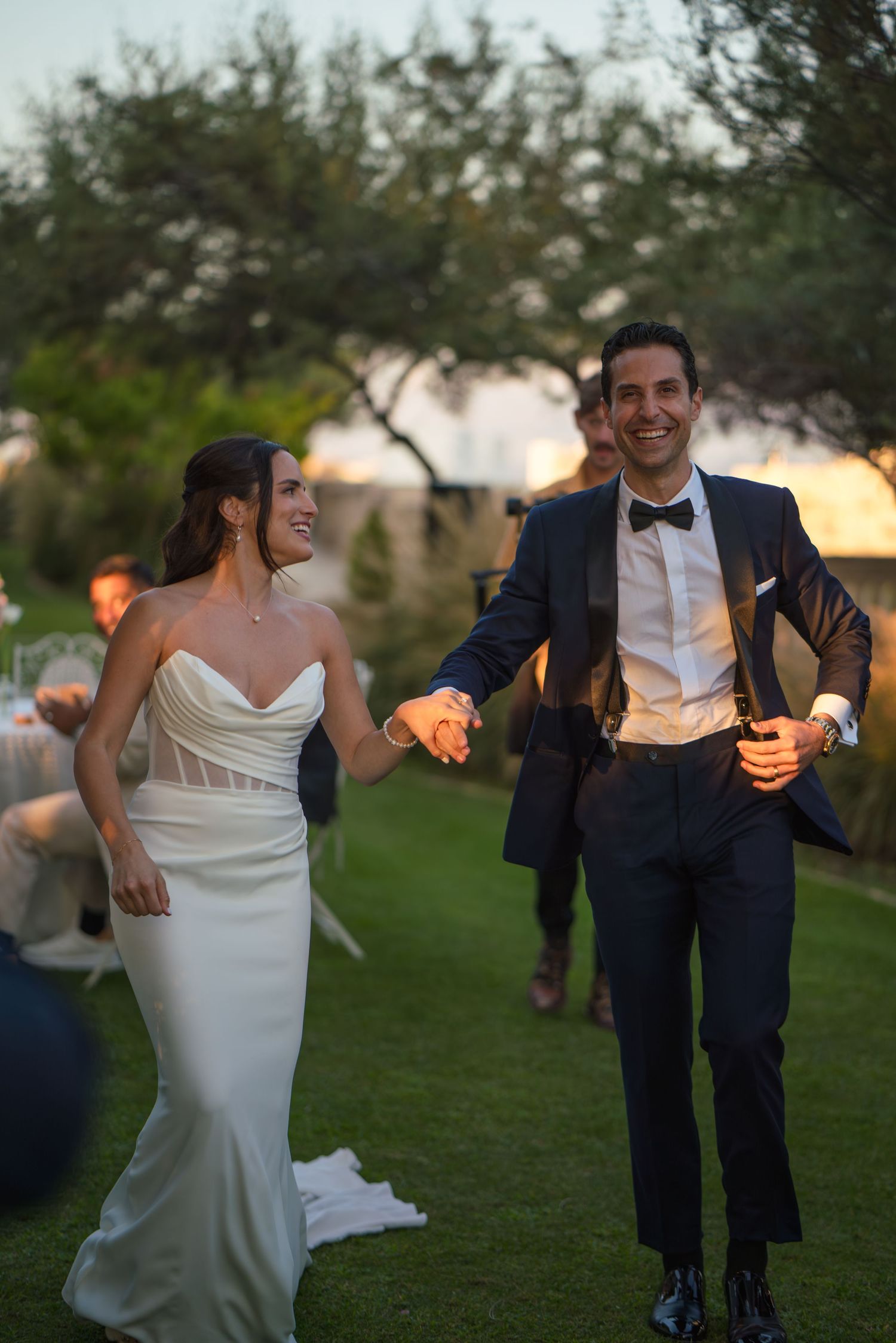 Couple dancing with glowing lanterns during evening garden reception.