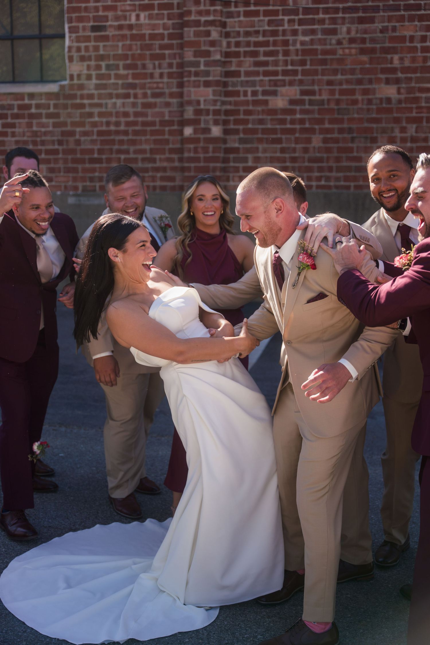 Joyful wedding party celebration with candid laughter and dancing.