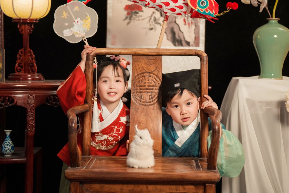 Happy family enjoying cozy home activities in Ming Dynasty Hanfu with soft studio lighting, by Imagine Image Studio Auckland.