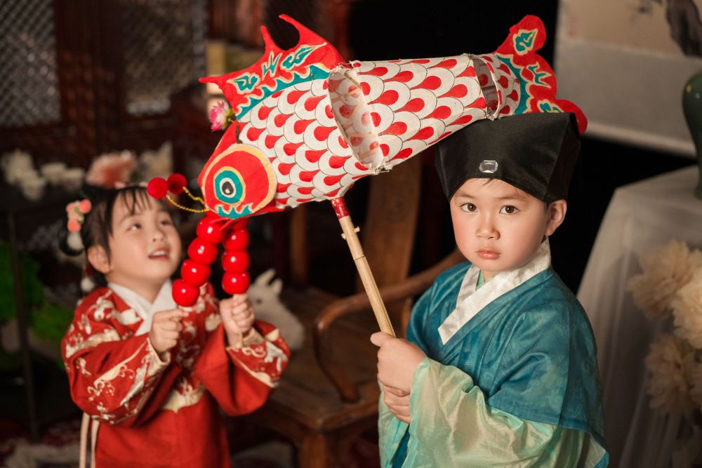Happy family enjoying cozy home activities in Ming Dynasty Hanfu with soft studio lighting, by Imagine Image Studio Auckland.