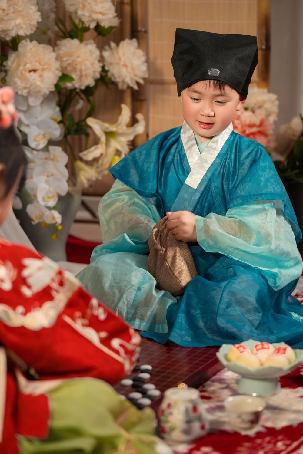 Happy family enjoying cozy home activities in Ming Dynasty Hanfu with soft studio lighting, by Imagine Image Studio Auckland.