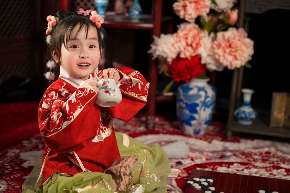 Happy family enjoying cozy home activities in Ming Dynasty Hanfu with soft studio lighting, by Imagine Image Studio Auckland.