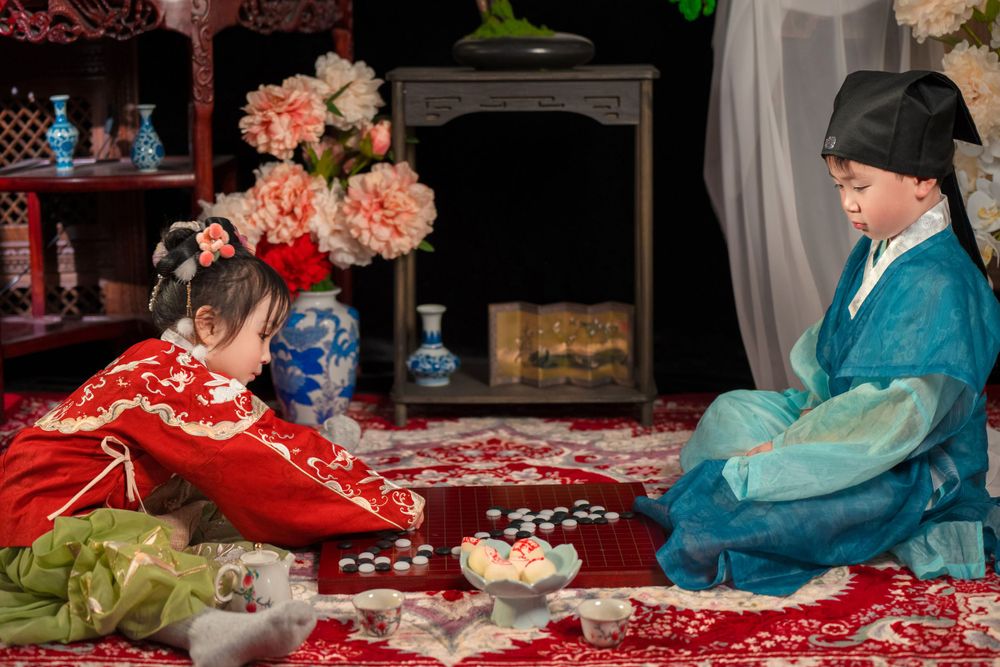 Happy family enjoying cozy home activities in Ming Dynasty Hanfu with soft studio lighting, by Imagine Image Studio Auckland.