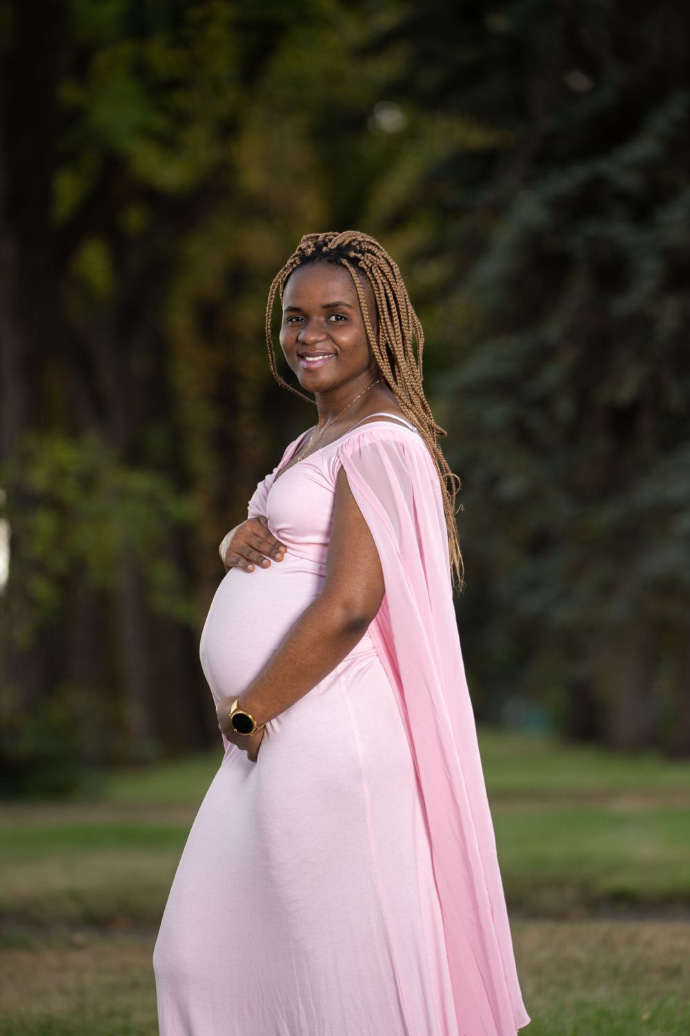Maternity photo session  outdoors at the lethbridge research station with a flowing pink dress and natural lighting.