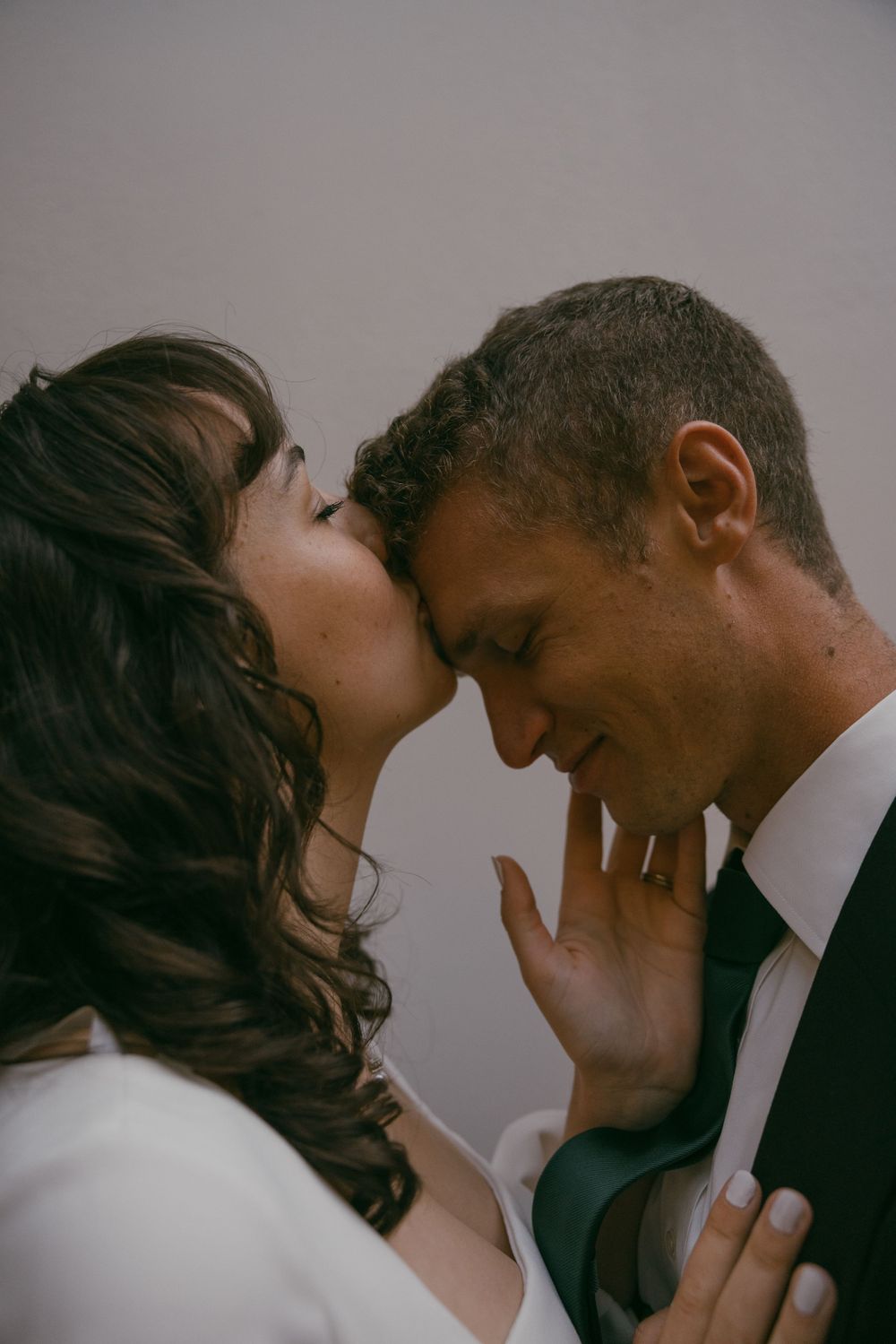 Intimate close-up wedding portrait showing tender moment between newlyweds.