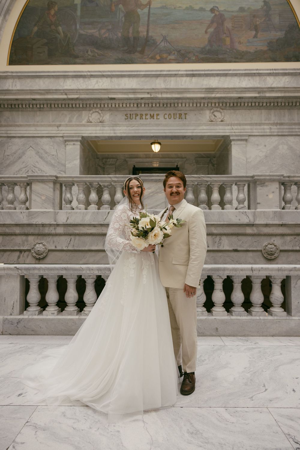 A wedding portrait at the Supreme Court building featuring elegant marble architecture.