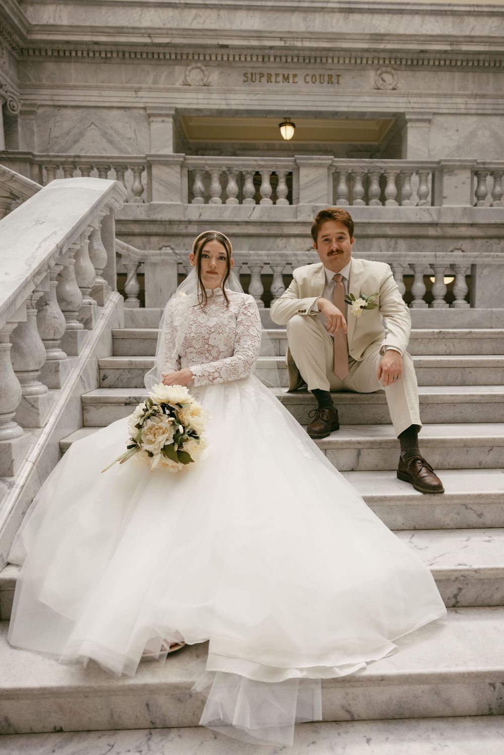 A classic wedding portrait on the Supreme Court steps with elegant architectural details.