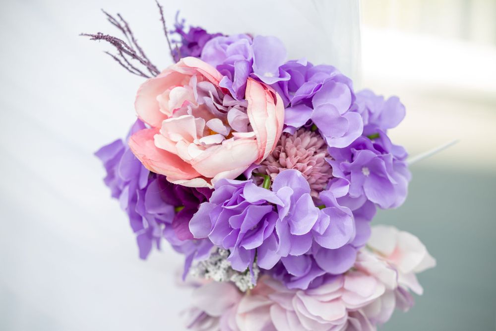 Close up of delicate pink and purple floral arrangement with soft focus.