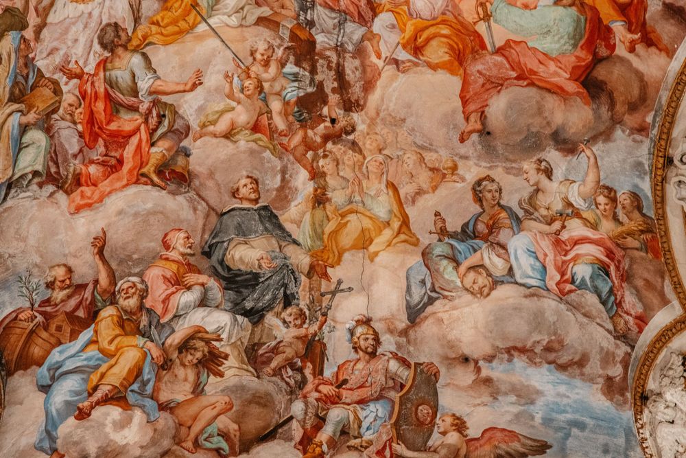 Detailed fresco painting on a church ceiling depicting religious figures in vibrant colors.