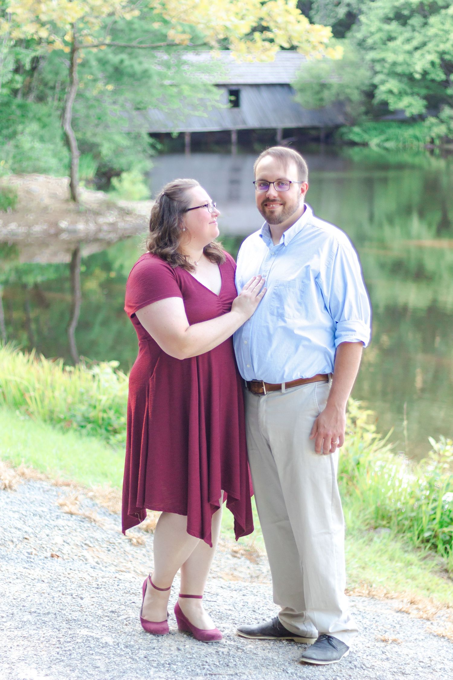 Couple standing in front of lake and covered bridge at Madison County Nature Trail