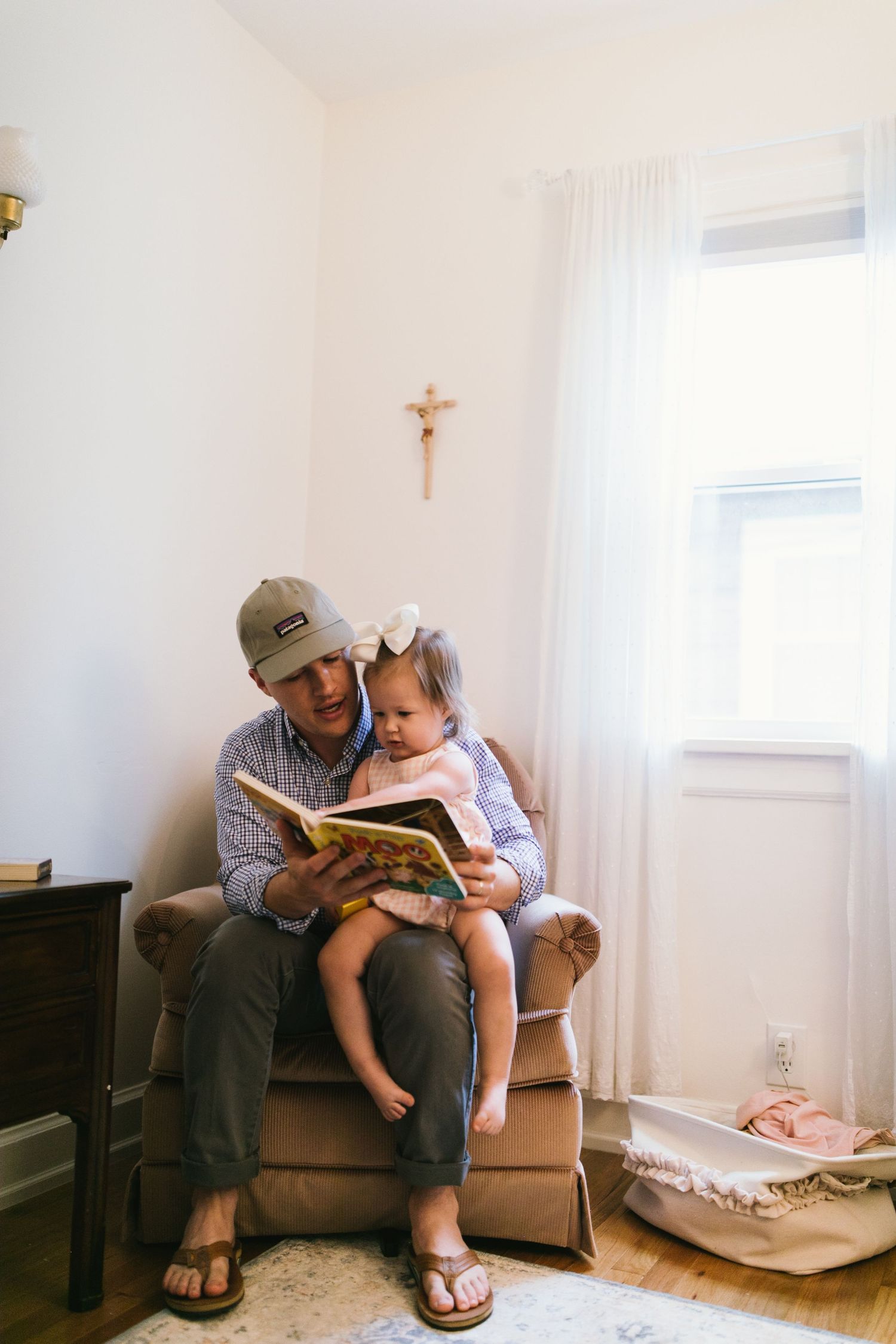 Heartwarming moment of reading together in cozy corner with window light.