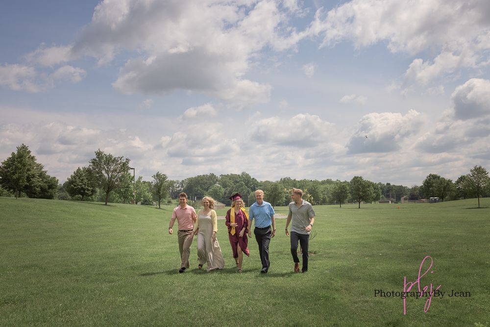 People gathering on a lush green golf course under partly cloudy skies for an outdoor event.